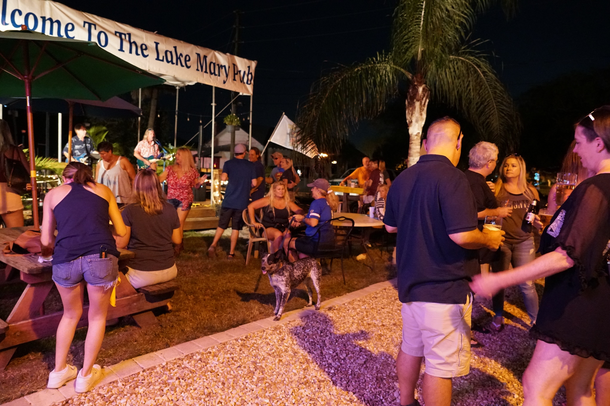 Crowd gathering around live music at the Lake Mary Pub outdoor tiki bar