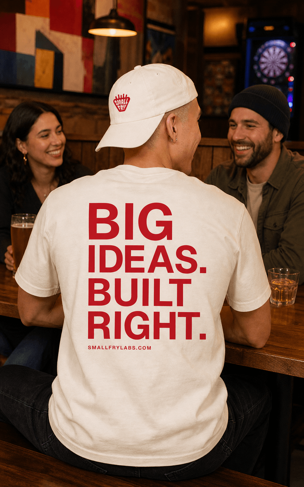 Friends together at a bar wearing Small Fry Labs Big Ideas Built Right merchandise